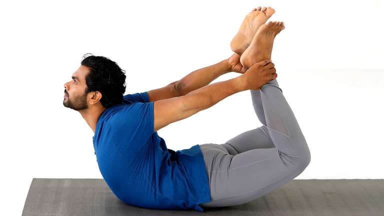 A man Practicing dhanurasana